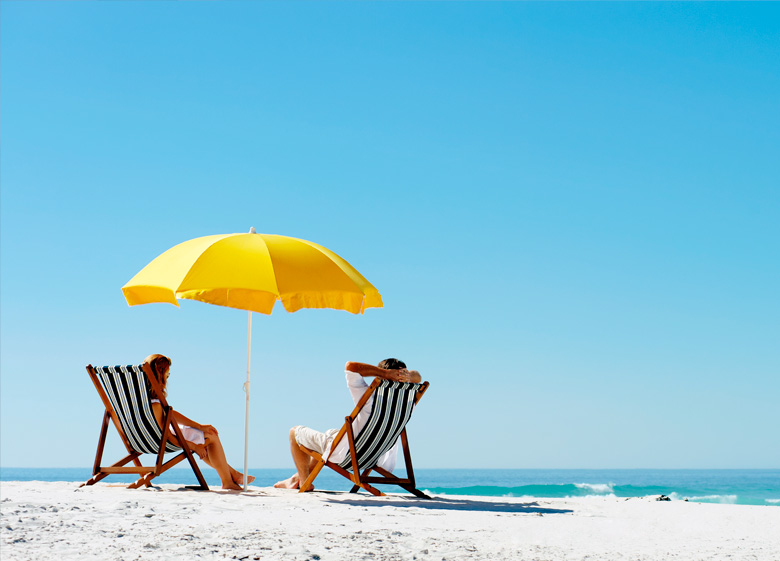 Couple sitting facing the sea on their summer holidays for the Labor day